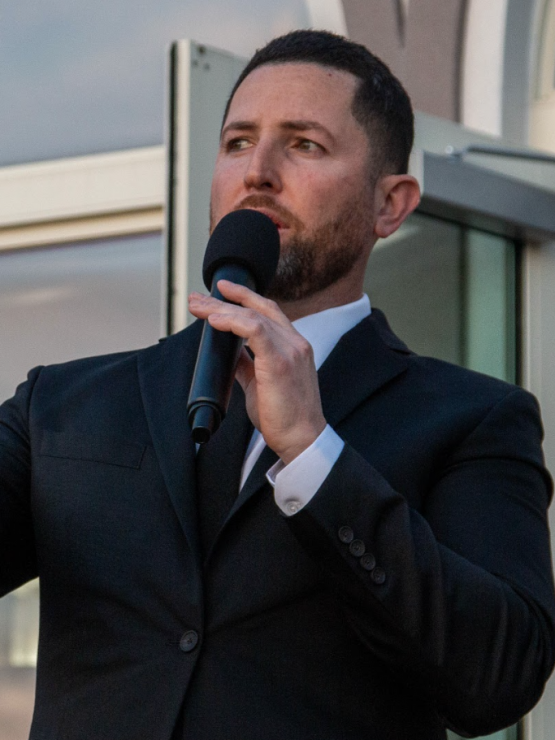 A Portrait of Mariano Jimenez, Jr. Speaking at an event using a microphone.